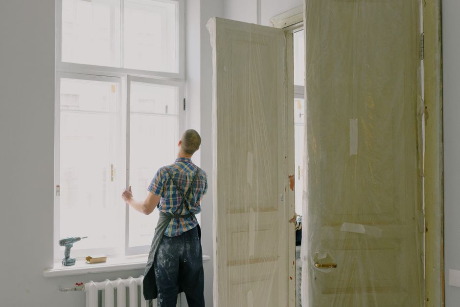 Workman installing new window frame in house