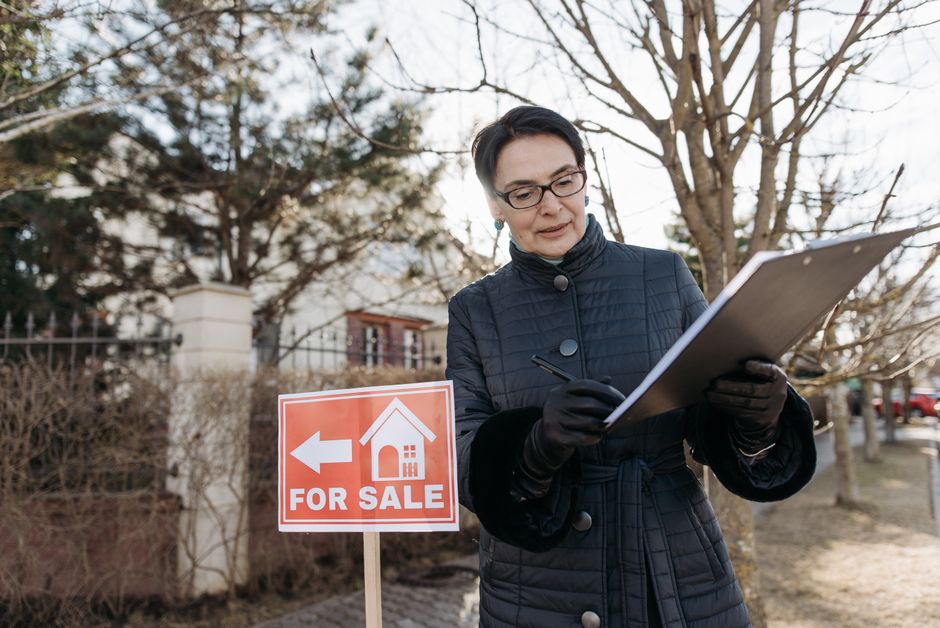 Inspector with clipboard checking house exterior